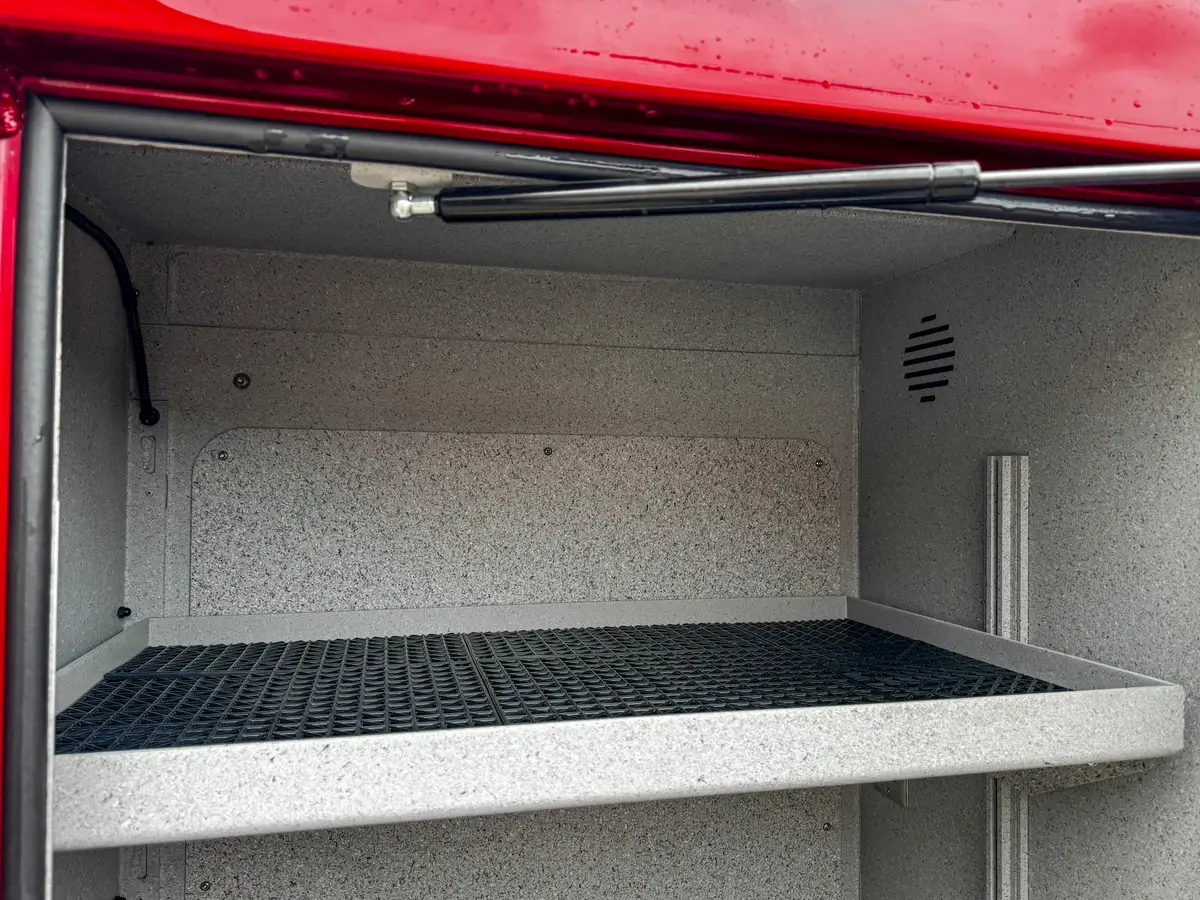 Open side compartment interior view with shelf and smooth side-wall liner.